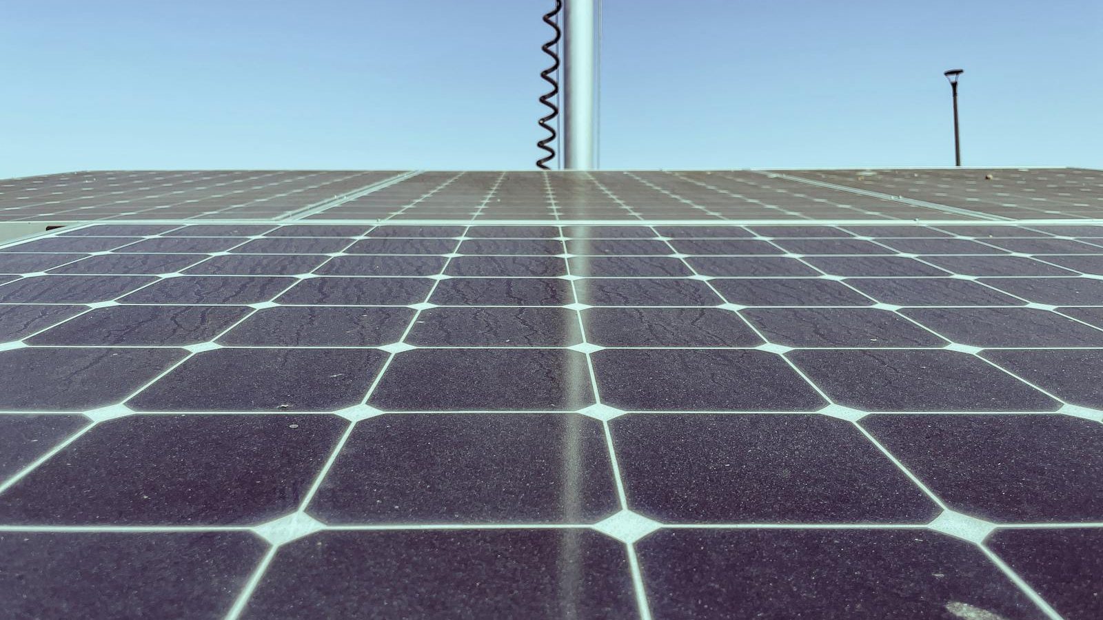 Sun shining on a row of rooftop solar panels