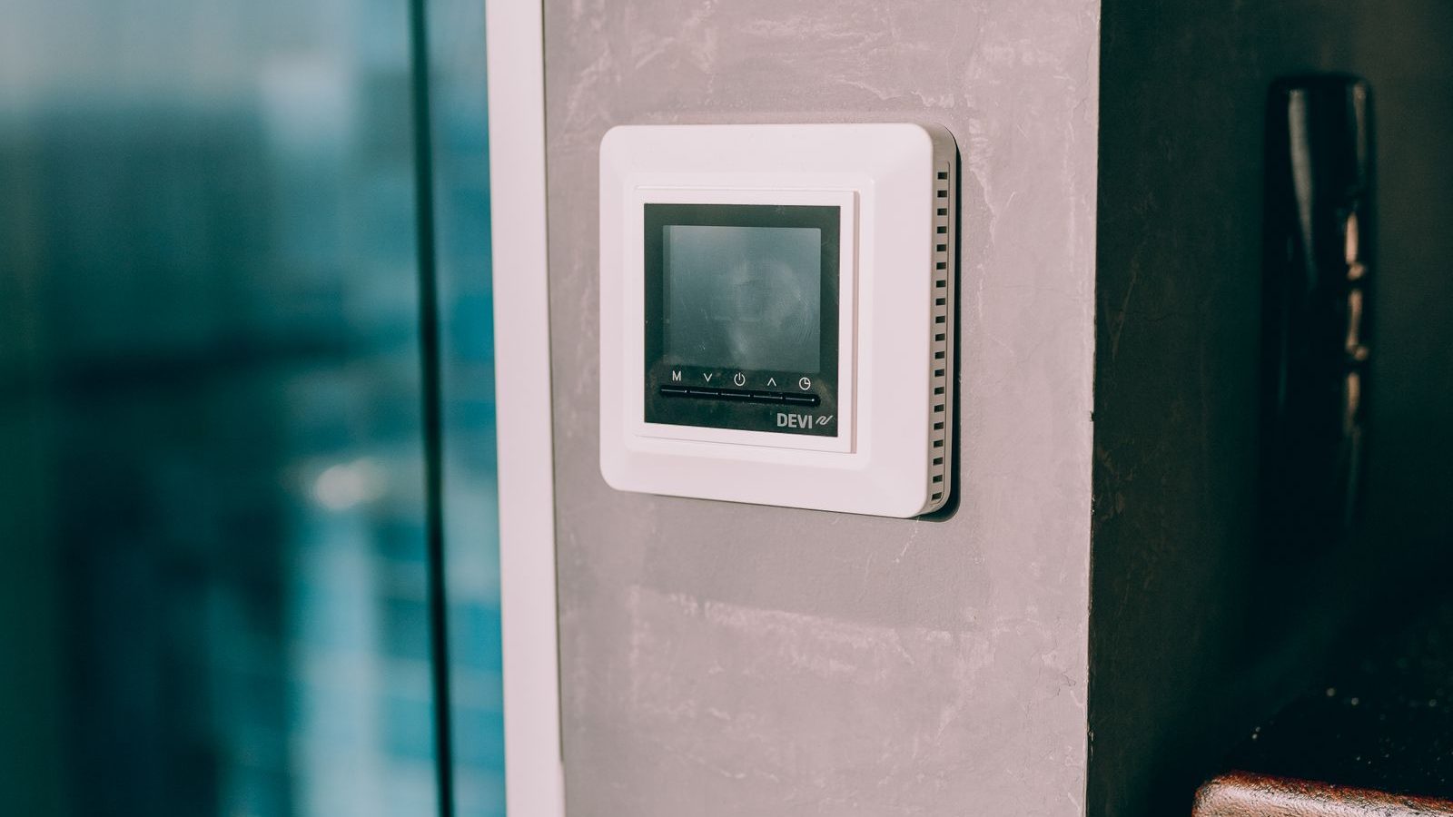 Hand adjusting a digital thermostat