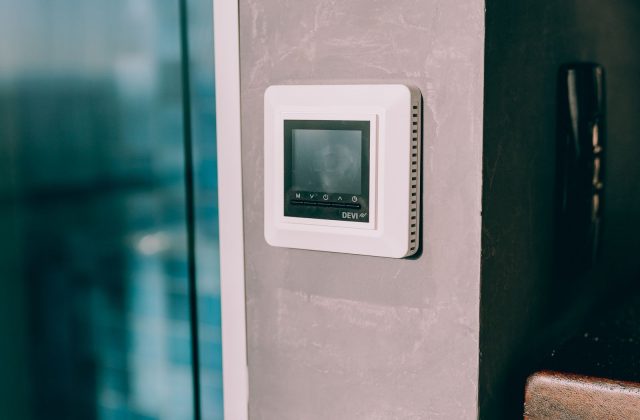 Hand adjusting a digital thermostat