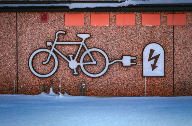 Electric vehicle plugged into a home charger on a frosty winter morning with snow on the ground