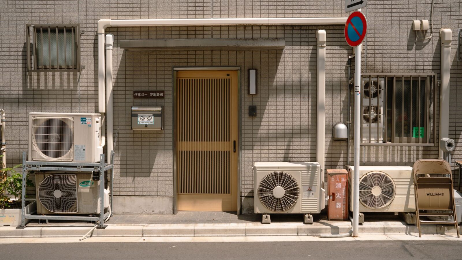 Modern air-source heat pump outdoor condenser unit installed on a concrete pad beside a residential home