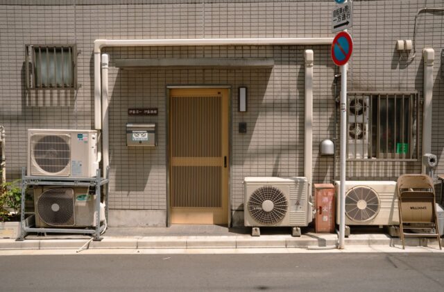 Modern air-source heat pump outdoor condenser unit installed on a concrete pad beside a residential home