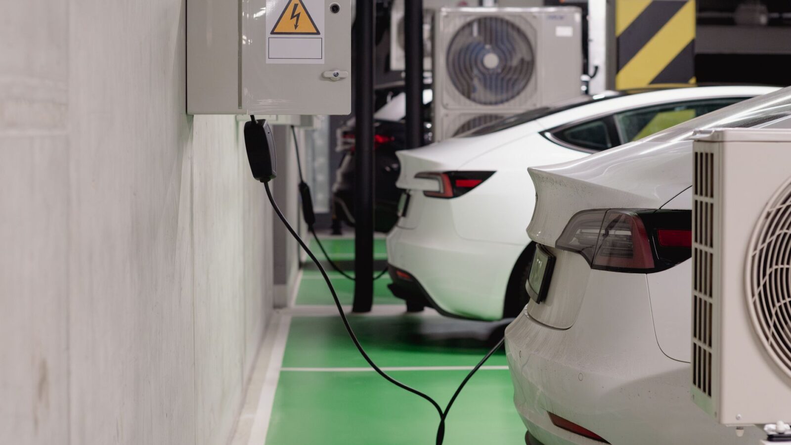Electric vehicle plugged into a DC fast charger at a highway travel stop during a road trip
