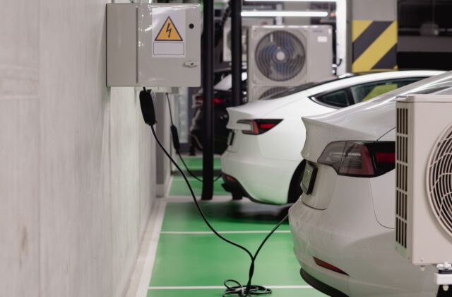 Electric vehicle plugged into a DC fast charger at a highway travel stop during a road trip